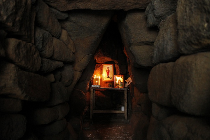 В маленькой и тесной пещерке едва теплится перед образами свет лампады освящая все пространство, и до наших дней она сохраняет истинную благодать Святого Духа и молитвенную силу преподобного.