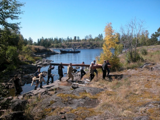 На руках несут крест к месту установки.