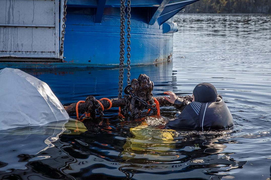 Дайвер 1XPEDITION Петрыкин Алексей крепит найденный якорь к крану-манипулятору научно-исследовательского судна «Анастасия» для подъема.